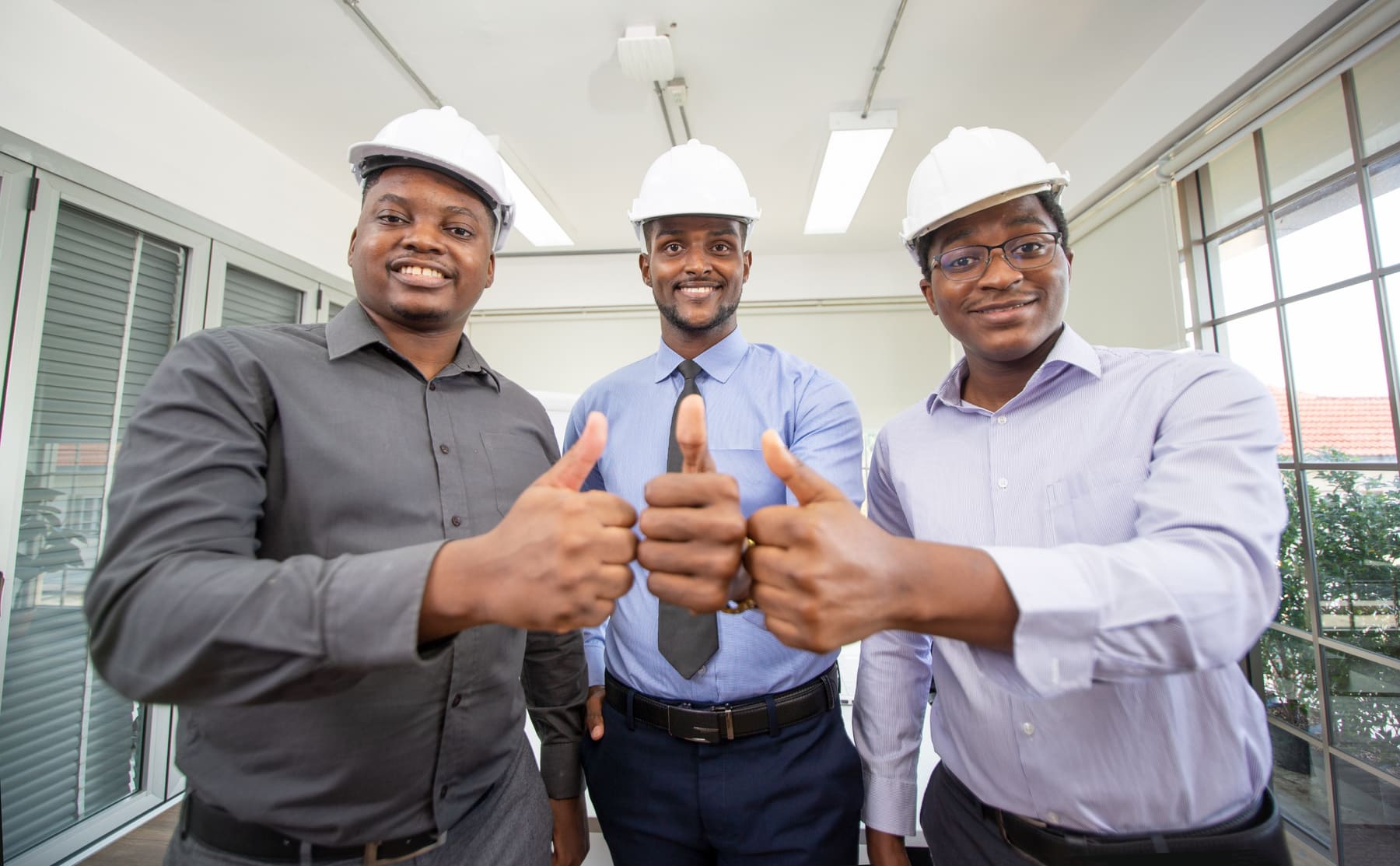 Three Aloft engineers in hard hats giving thumbs up