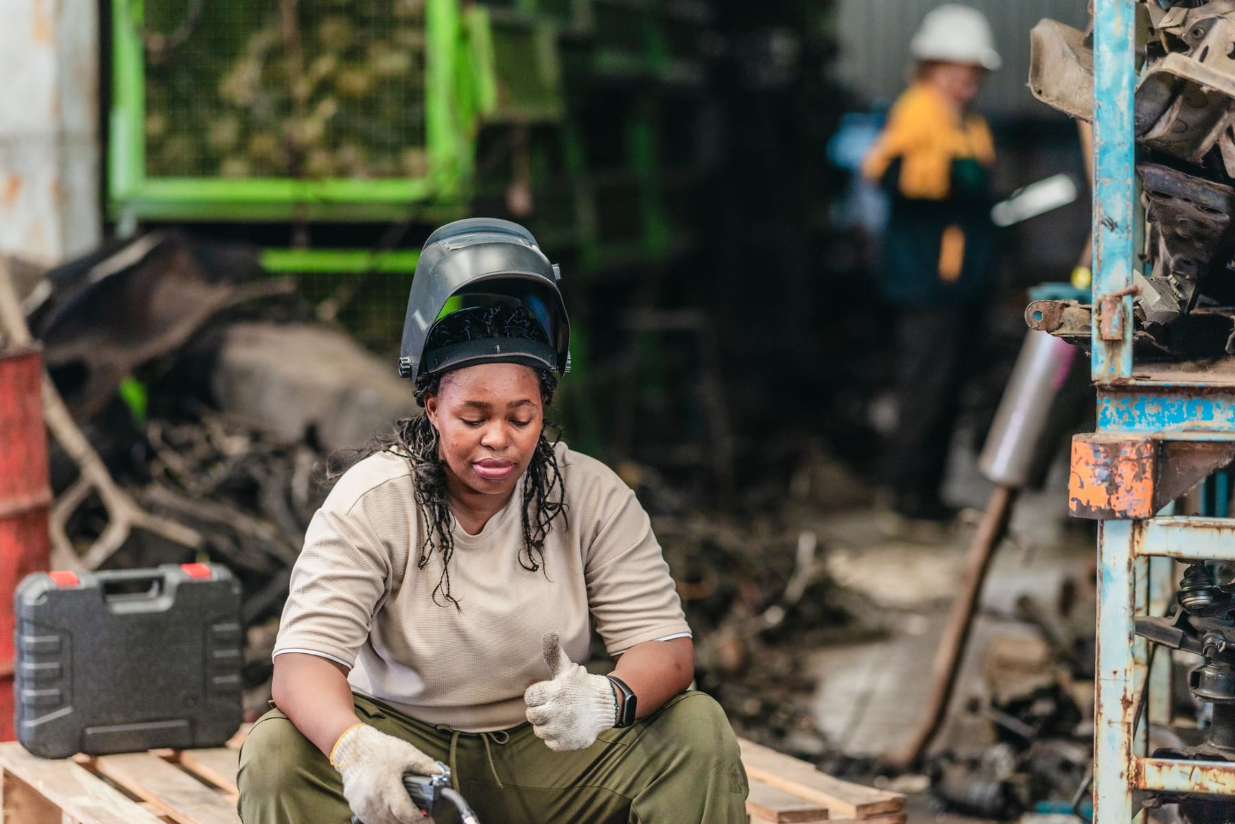 Welder in protective helmet and gloves